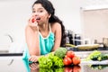 Indian woman eating healthy apple in her kitchen Royalty Free Stock Photo