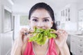 Indian woman eating raw spinach at home