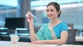 Indian Woman Flying Paper Plane while Sitting at Work