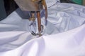 Indian woman hands stitching white cloth with the help of a sewing machine