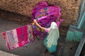 Indian woman hanging laundry on roof of house. Nandgaon. India