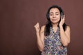Indian woman in headphones, holding imaginable microphone Royalty Free Stock Photo