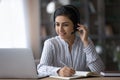Indian woman in headphones work online on laptop