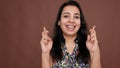 Indian woman holding fingers crossed for good luck in studio Royalty Free Stock Photo