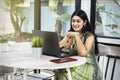 Indian woman with laptop on the table holding coffee Royalty Free Stock Photo