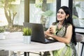 Indian woman with laptop on the table holding coffee Royalty Free Stock Photo