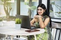 Indian woman with laptop on the table holding coffee Royalty Free Stock Photo