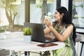 Indian woman with laptop on the table holding coffee Royalty Free Stock Photo