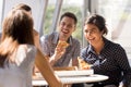 Indian woman laughing, eating pizza with colleagues in office Royalty Free Stock Photo