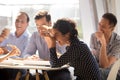 Indian woman laughing eating pizza with diverse coworkers in off Royalty Free Stock Photo