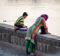 An Indian woman leaning over a lakeside wall