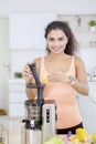 Indian woman makes fruit juice with juicer machine