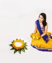 Indian woman making rangoli using flowers