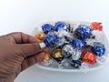 Indian woman picking Lindor Swiss chocolate from a bowl Royalty Free Stock Photo