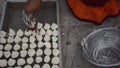 Indian woman is preparing Daler bori on a net in sunny day. It is a form of dried lentil dumplings popular in Bengali cuisine