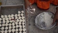 Indian woman is preparing Daler bori on a net in sunny day. It is a form of dried lentil dumplings popular in Bengali cuisine