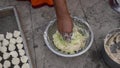 Indian woman is preparing mixture Daler bori in a bowl in sunny day. It is a form of dried lentil dumplings popular in Bengali