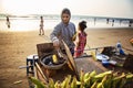 Indian woman preparing roasted sweet yellow corn at the beach