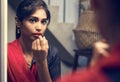 Indian woman putting on a lipstick