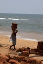 The Indian woman in a sari stones for building on the head on a beach. India Goa Royalty Free Stock Photo