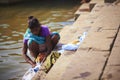 Indian woman in sari washing clothes in the river