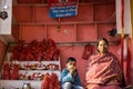 Indian woman shopkeeper with her child at shop selling religious material at Haridwar Uttarakhand India