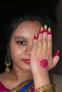 An Indian woman showing her wedding ring with one eye covered. Selective focus on the golden ring. Shy woman disguising her