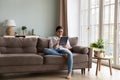 Indian woman sit on couch using digital tablet Royalty Free Stock Photo