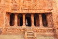 Indian woman standing on stairs to 6th century cave Hindu temple. Old architecture landmark in Badami, India Royalty Free Stock Photo