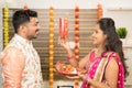 Indian woman in traditional dress seeing her husband or partner through sieve during Hindu Indian religious karwa chauth