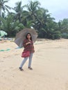 An Indian woman with an umbrella at Kundapura Beach. Royalty Free Stock Photo