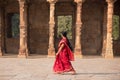 Indian woman walking through courtyard of Quwwat-Ul-Islam mosque