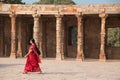 Indian woman walking through courtyard of Quwwat-Ul-Islam mosque