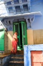 Indian woman wearing sari and smiling in front of her colorful house Royalty Free Stock Photo