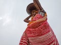 an indian woman worker transporting building materials on head at sky background in india dec 2019