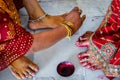 Indian women adorning feet with bright red dye Alta mahavar