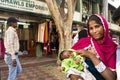 Indian women beggar or untouchables caste hold baby and begging money from travelers people in New Delhi, India