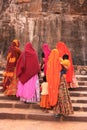 Indian women in colorful saris with kids walking up the stairs a