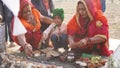 Indian women offer milk or sacred food by hand to the idol of the god. Hinduism and festival concept