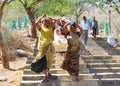 Indian women in sari carry the palanquin with the old woman