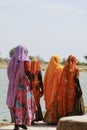 Indian women in saris walking next to a lake in Jaisalmer, India