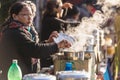 Indian women selling tea with steam from stainless steel bowl in the market near Tiger Hill in winter at Darjeeling, India