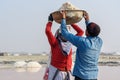 Indian workers putting basin with salt on head of woman on Sambhar Salt Lake. Rajasthan. India