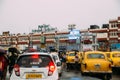 Indian yellow taxis and other cars waiting in the rain with umbrella near the area of Howrah Junction railway station