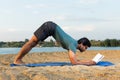 Yogi reading in downward dog position