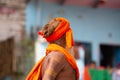 Indian yogi or sannyasi man, of hinduist religion, dressed in orange with rasta hair, walking along the ghats of the holy city of Royalty Free Stock Photo