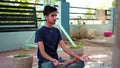 A boy is meditating at home in India. Indian young boy in a black traditional shirt sitting in a lotus position