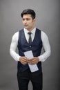 Indian young business man giving presentation on a topic holding folder in hand in formal wear wearing white shirt, black tie, Royalty Free Stock Photo