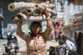 Indian young woman on the head of thick bamboo stalks