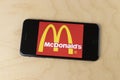 McDonald`s logo on a smartphone. McDonald`s is offering delivery and drive thru service during social distancing